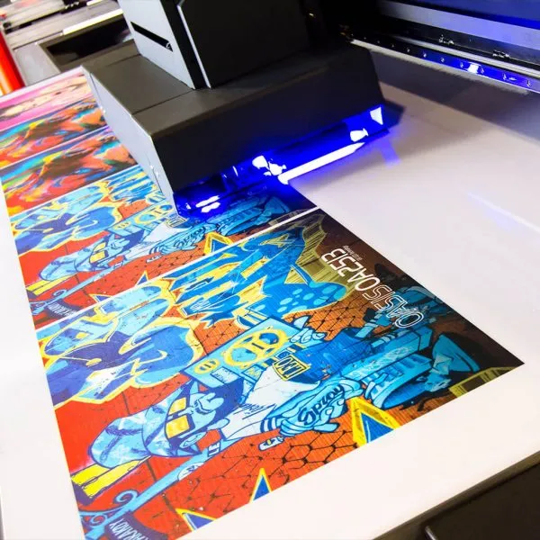 Impresora UV imprimiendo arte a todo color sobre material rígido con luz UV de curado